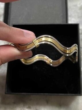 vintage two-tone wavy bangle bracelet by Avon 
featuring silver & gold tones